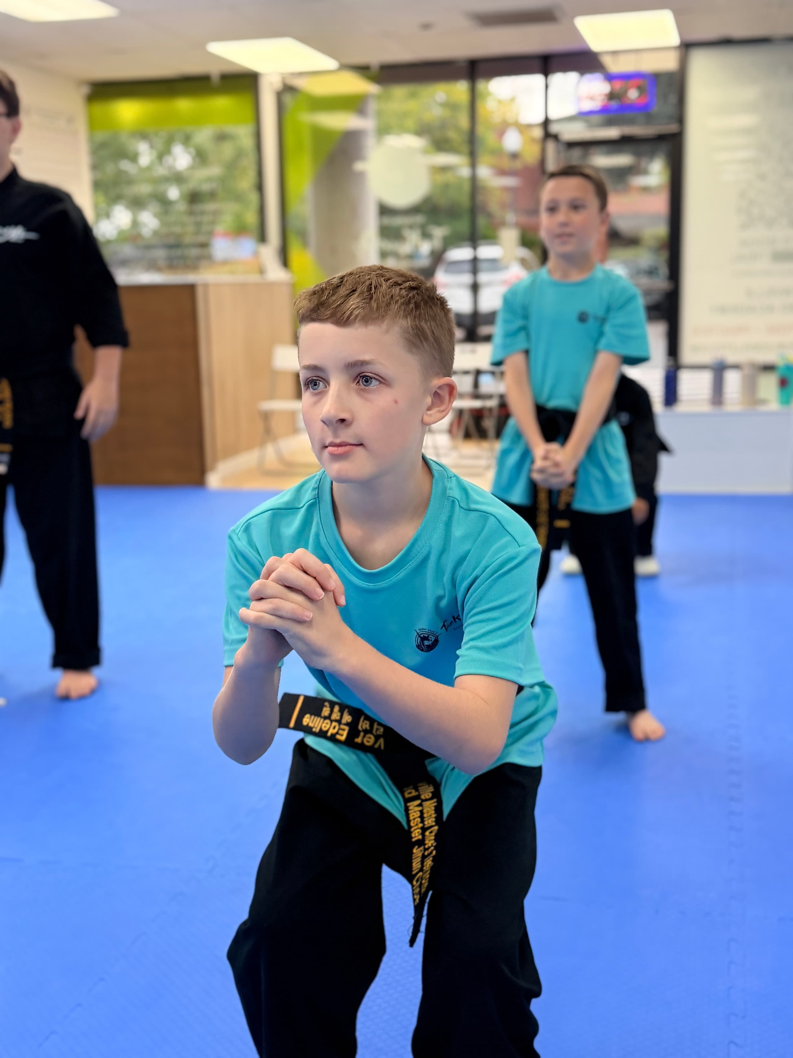 Focused student holding a low stance during a conditioning drill