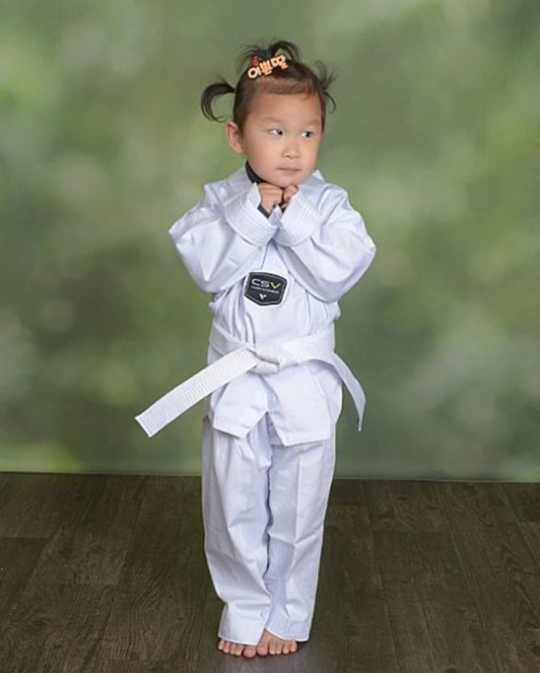 Little Tigers student in a white uniform holding a ready stance