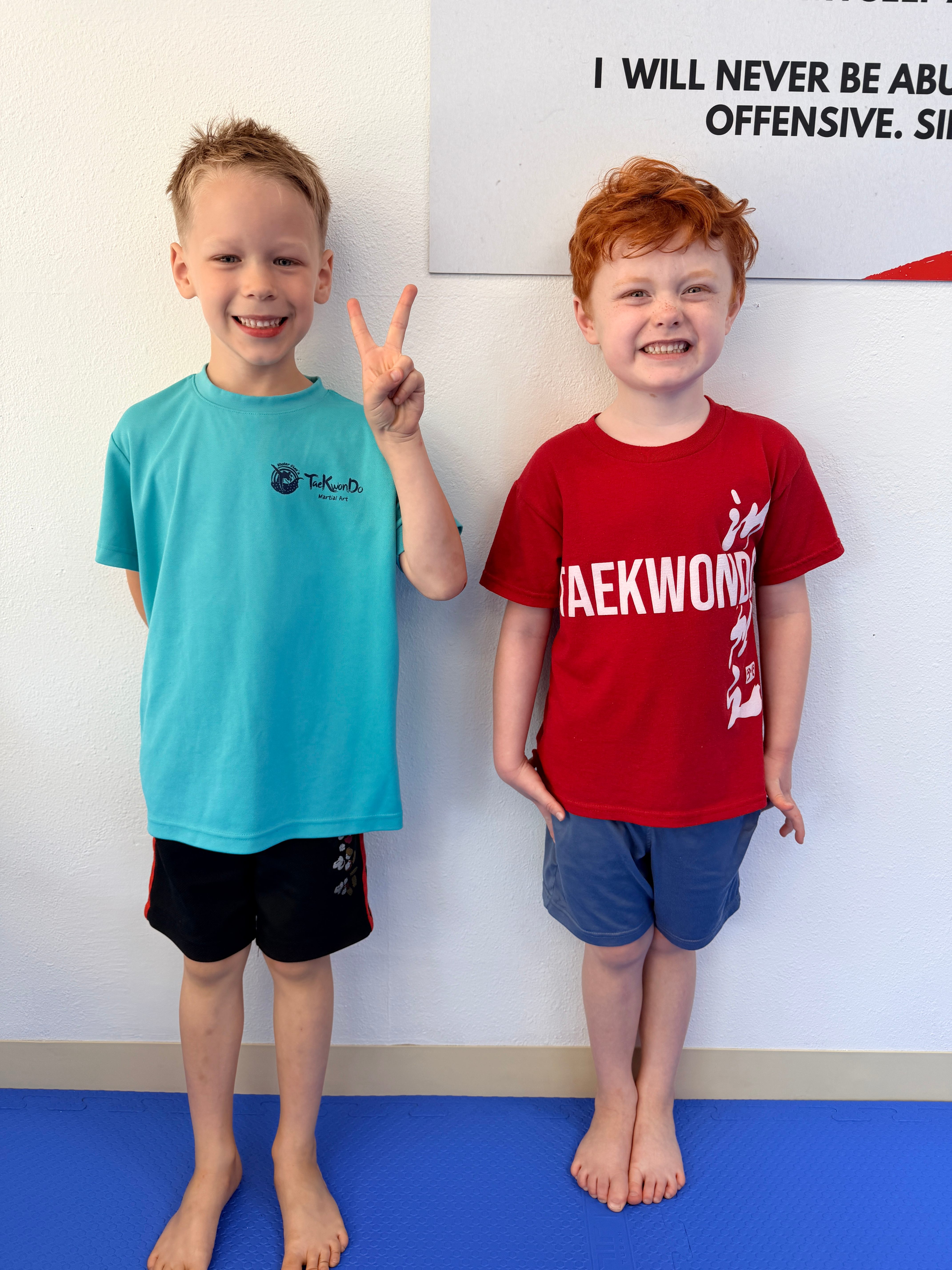 Two young students smiling in Taekwondo T-shirts