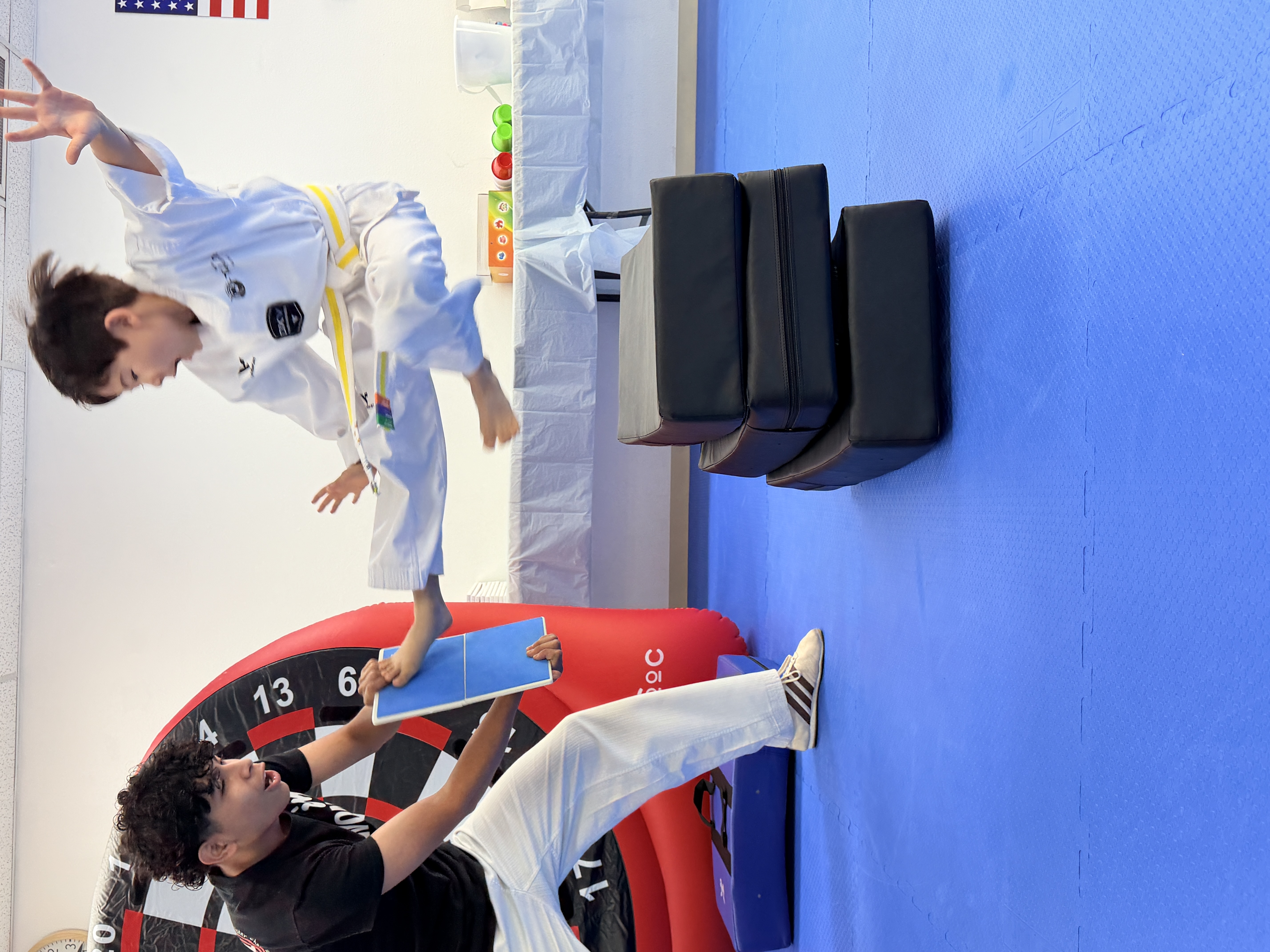 Yellow belt student breaking a board with a flying kick