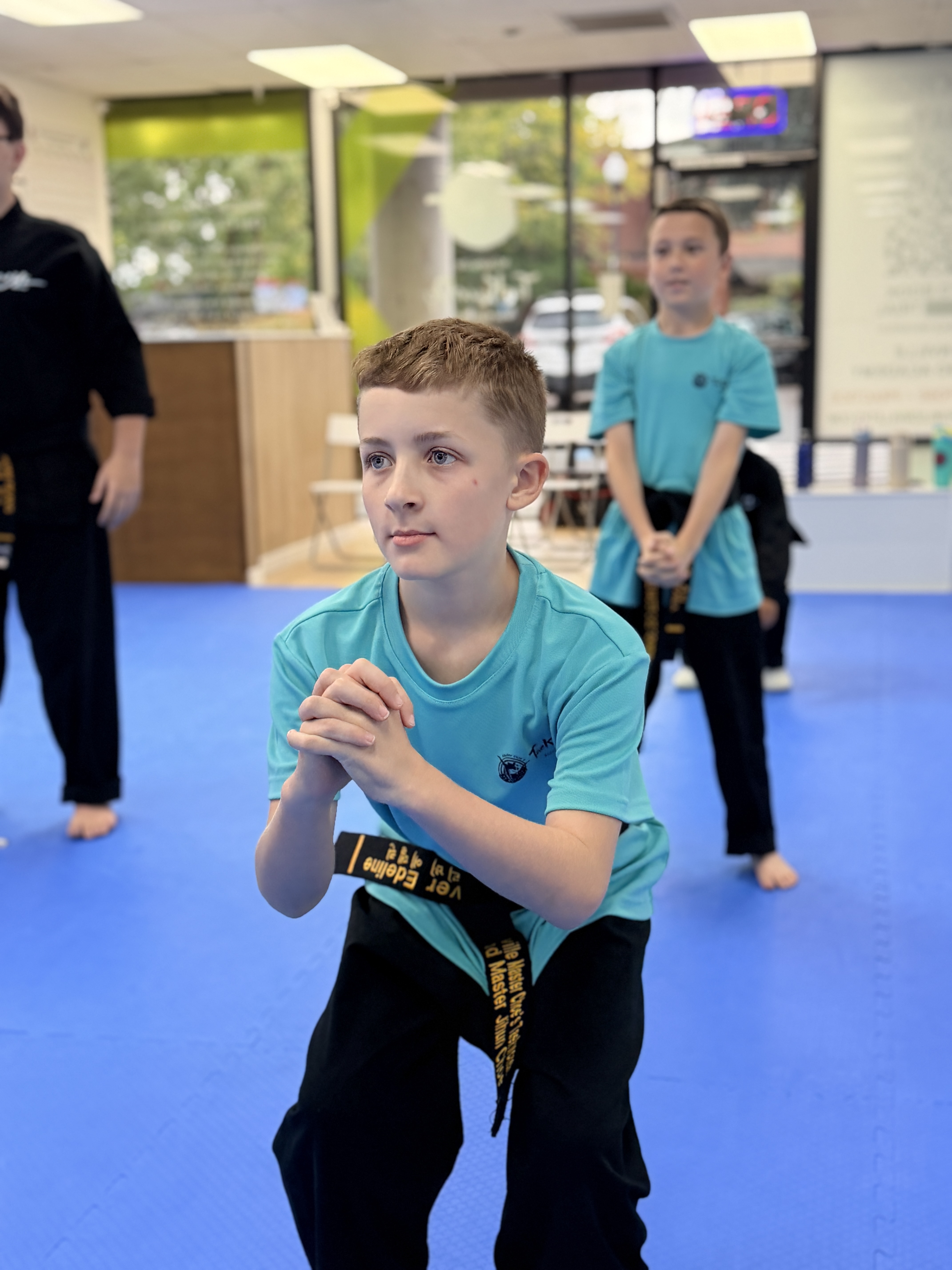 Focused student holding a low stance during a conditioning drill