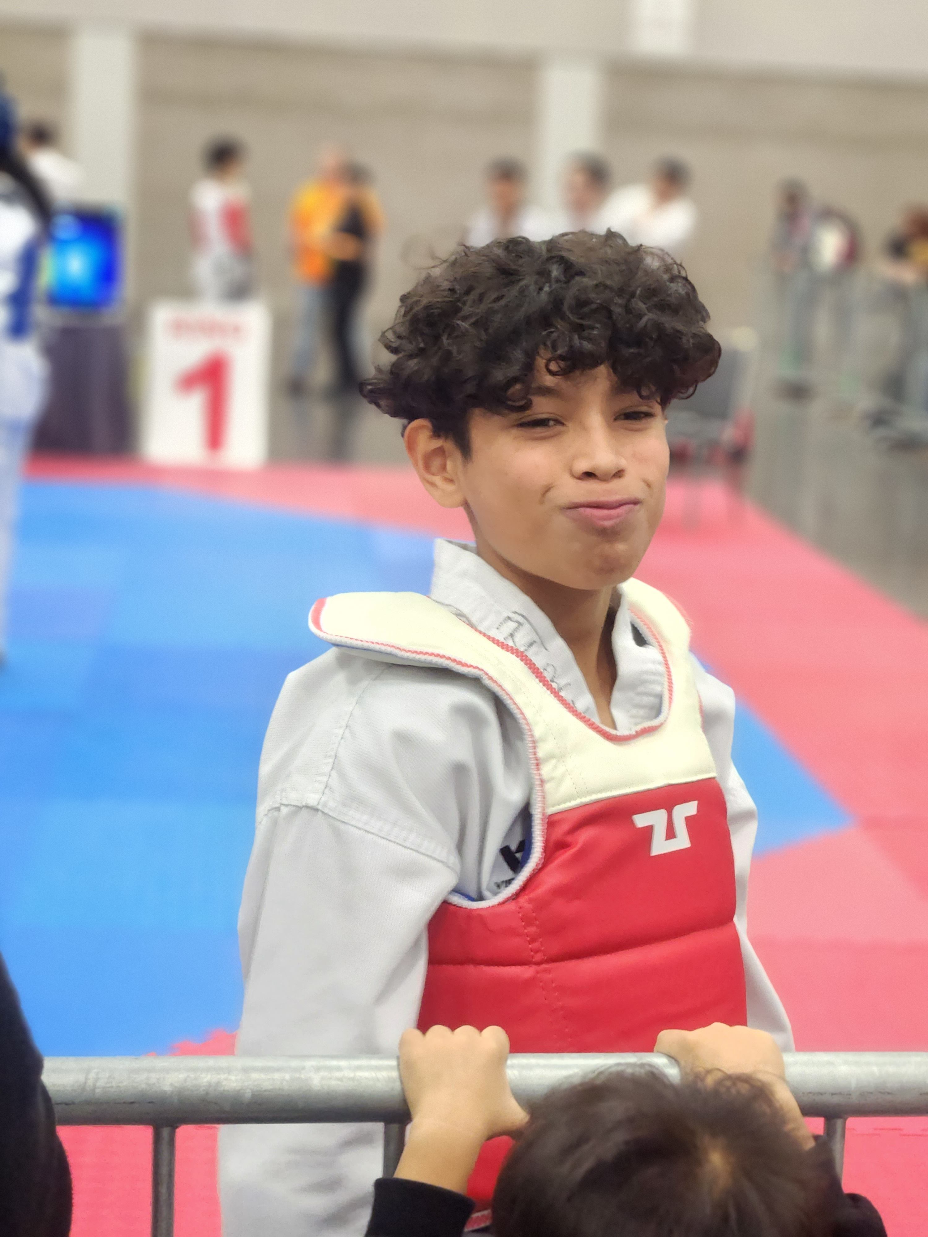 Student smiling ringside at a Taekwondo tournament