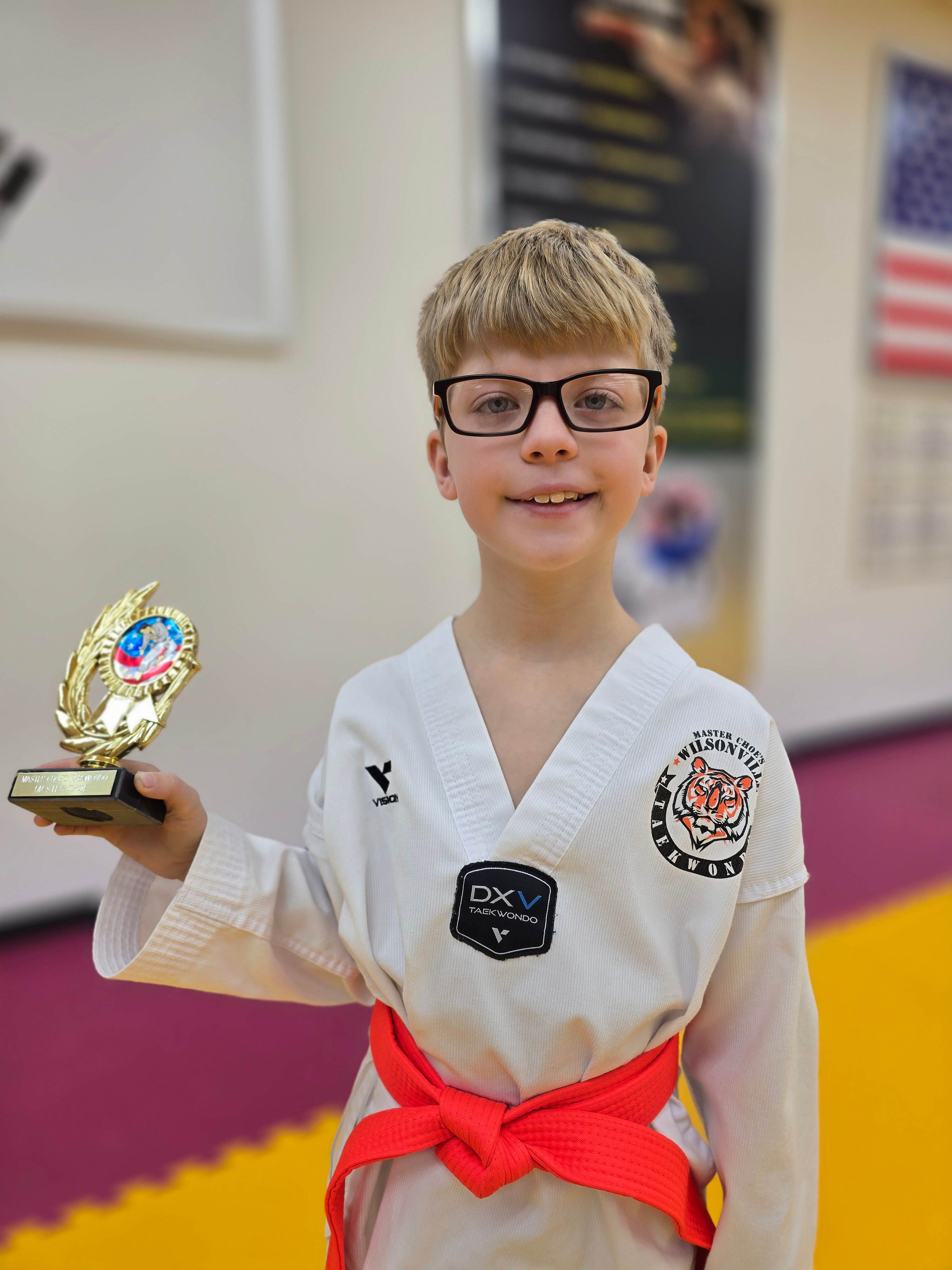 Student with glasses holding a trophy