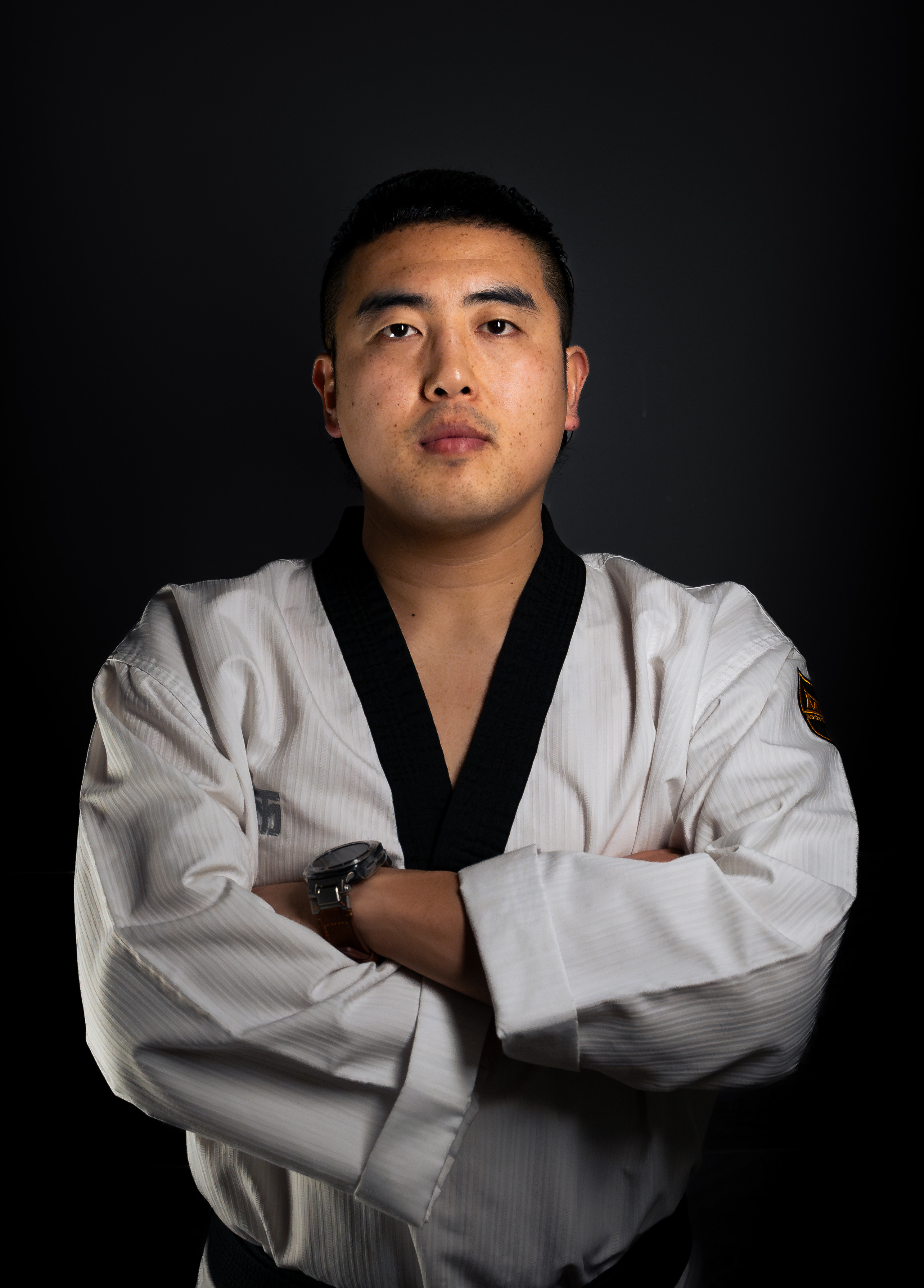 Portrait of Master Choe with arms crossed in a white dobok
