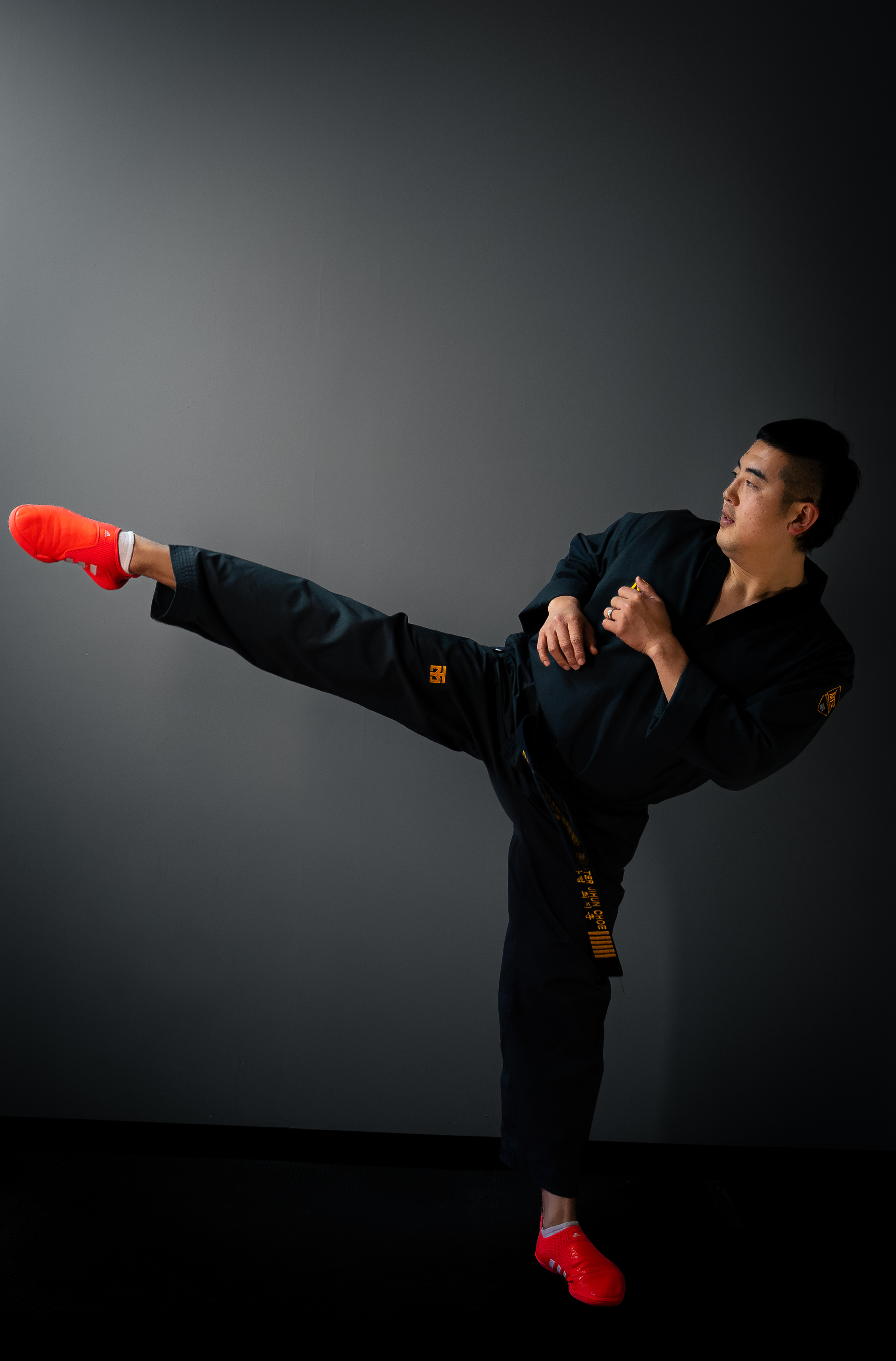 Master Choe throwing a side kick in a black dobok