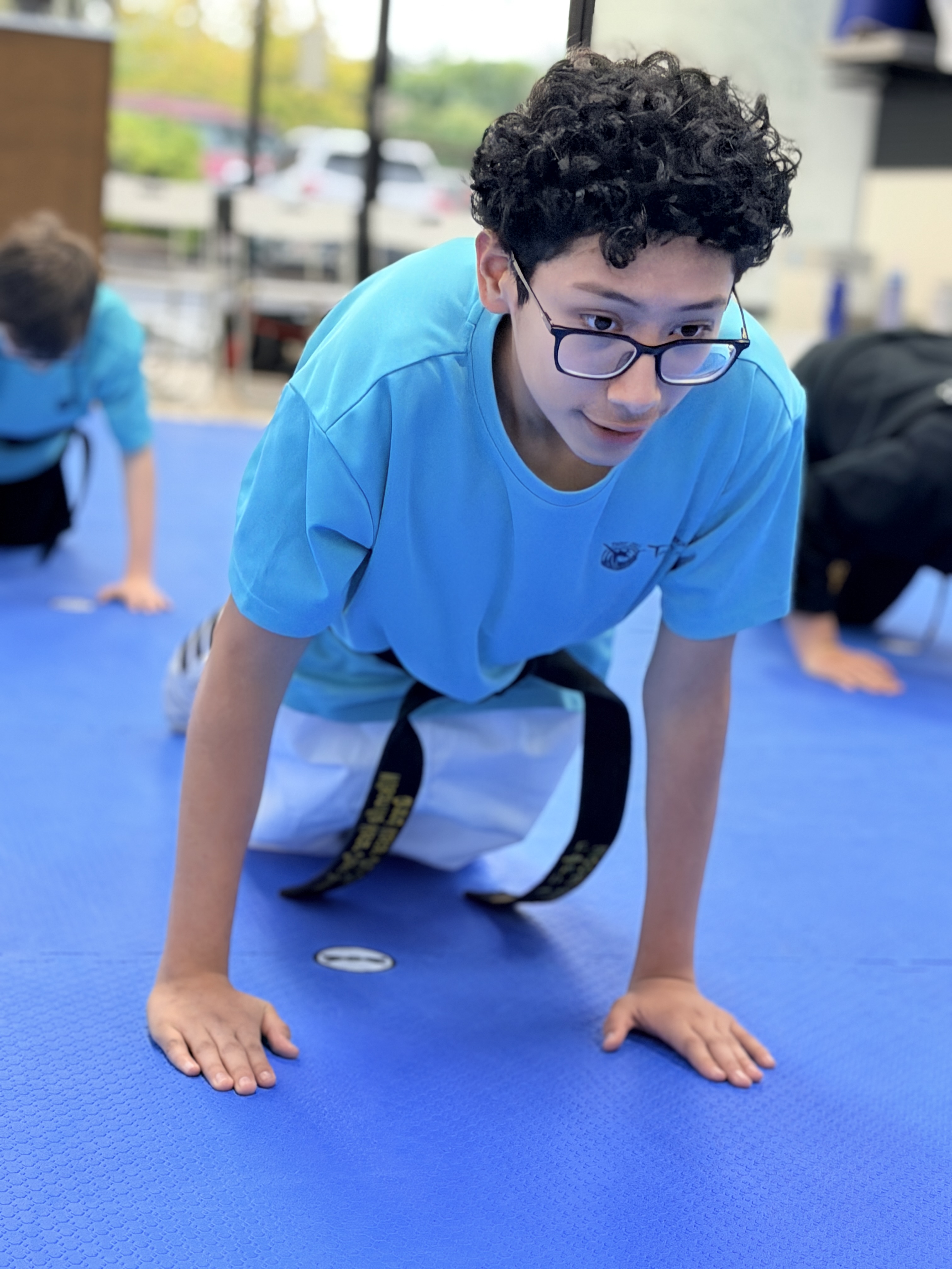 A student in glasses doing push-ups during warm-ups